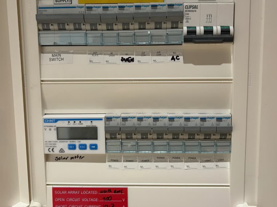 A switchboard with circuit breakers labelled across two rows and multiple-supply warning signage