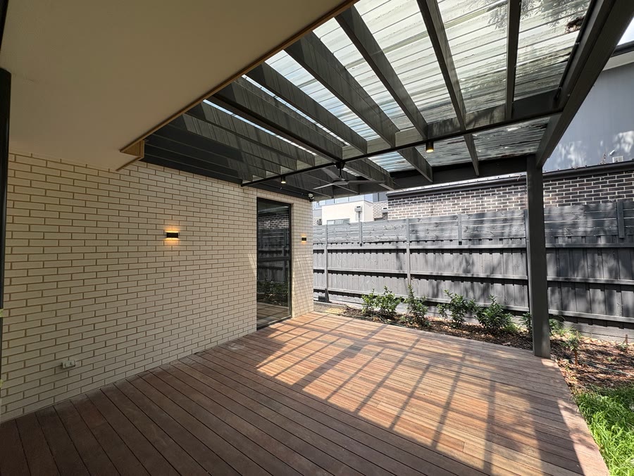 Covered timber deck with wall lights fitted to the brickwork