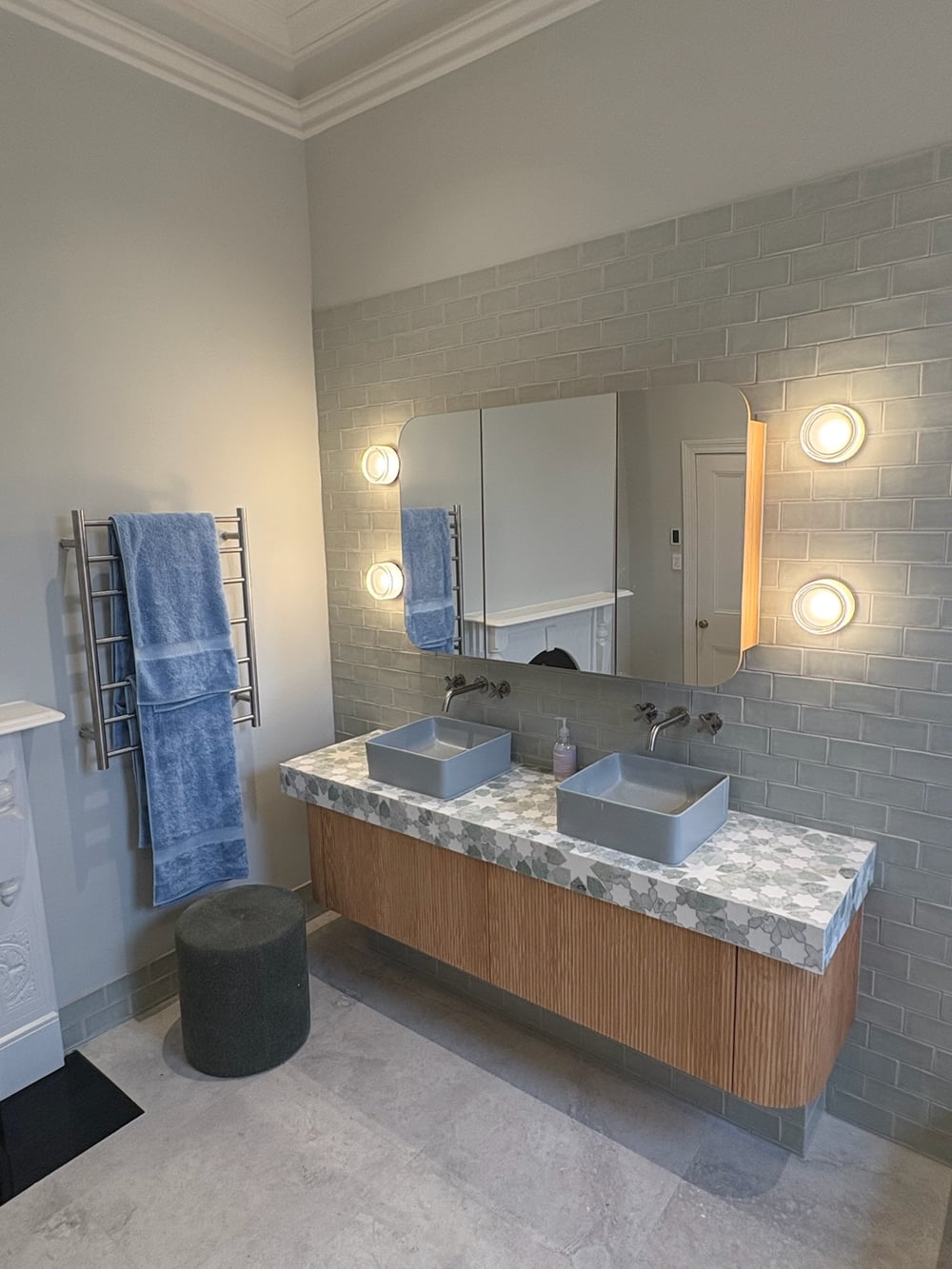 Bathroom double vanity with globe wall sconces flanking a large mirror